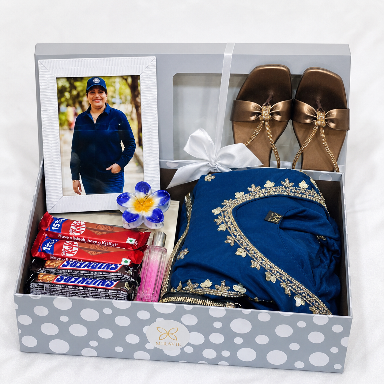 Premium women's gift hamper with blue party wear dress, stylish chappal, wallet, perfume, chocolates and photo frame in luxury gift box