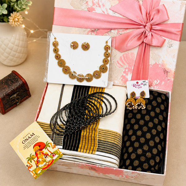 Kerala Onam gift hamper featuring a Kasavu saree, traditional necklace set, black bangles, designer jhumka earrings, Happy Onam greeting card, and premium pink gift box by Miravie.