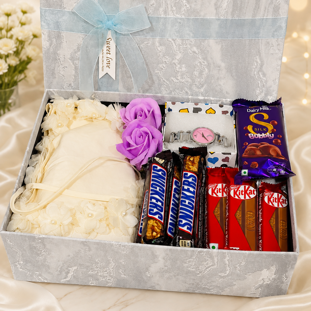 Elegant women's birthday gift hamper with dress, wristwatch, artificial flowers and Dairy Milk, Snickers and KitKat chocolates in a premium gift box