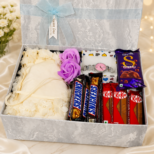 Elegant women's birthday gift hamper with dress, wristwatch, artificial flowers and Dairy Milk, Snickers and KitKat chocolates in a premium gift box