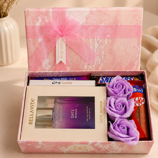 Luxury perfume and chocolate gift hamper featuring Bella Vita Date Woman perfume, Dairy Milk Silk, Galaxy, Snickers, KitKat chocolates, purple decorative roses, and a premium pink gift box by Miravie.
