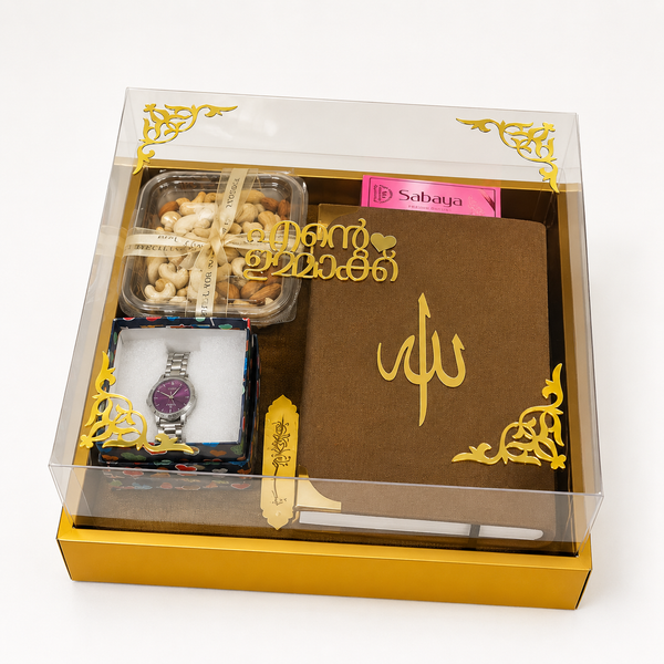 Premium mother's Islamic gift hamper featuring a Quran, prayer mat, women's wristwatch, mixed nuts, Sabaya attar, personalized acrylic "Ente Ummaakk" name plaque, and a luxury transparent gift box.