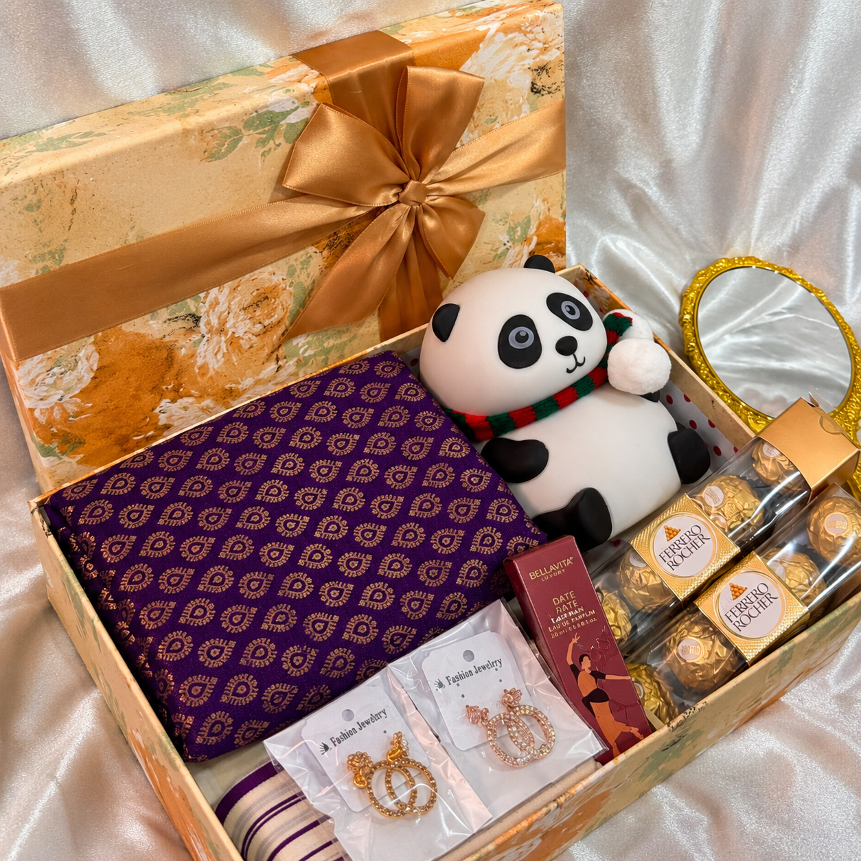 Premium Kerala gift hamper featuring a Set Mundu, lighting panda lamp, Ferrero Rocher chocolates, Bella Vita mini perfume, fashion earrings, lipstick, mini bouquet, and luxury floral gift box for festive and special occasion gifting.