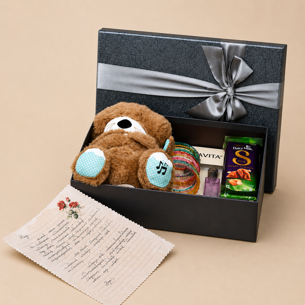 Premium breakup gift hamper featuring a soft teddy bear, Dairy Milk Silk chocolate, Bella Vita mini perfume, colorful bangles, handwritten message card, and black gift box with satin ribbon.