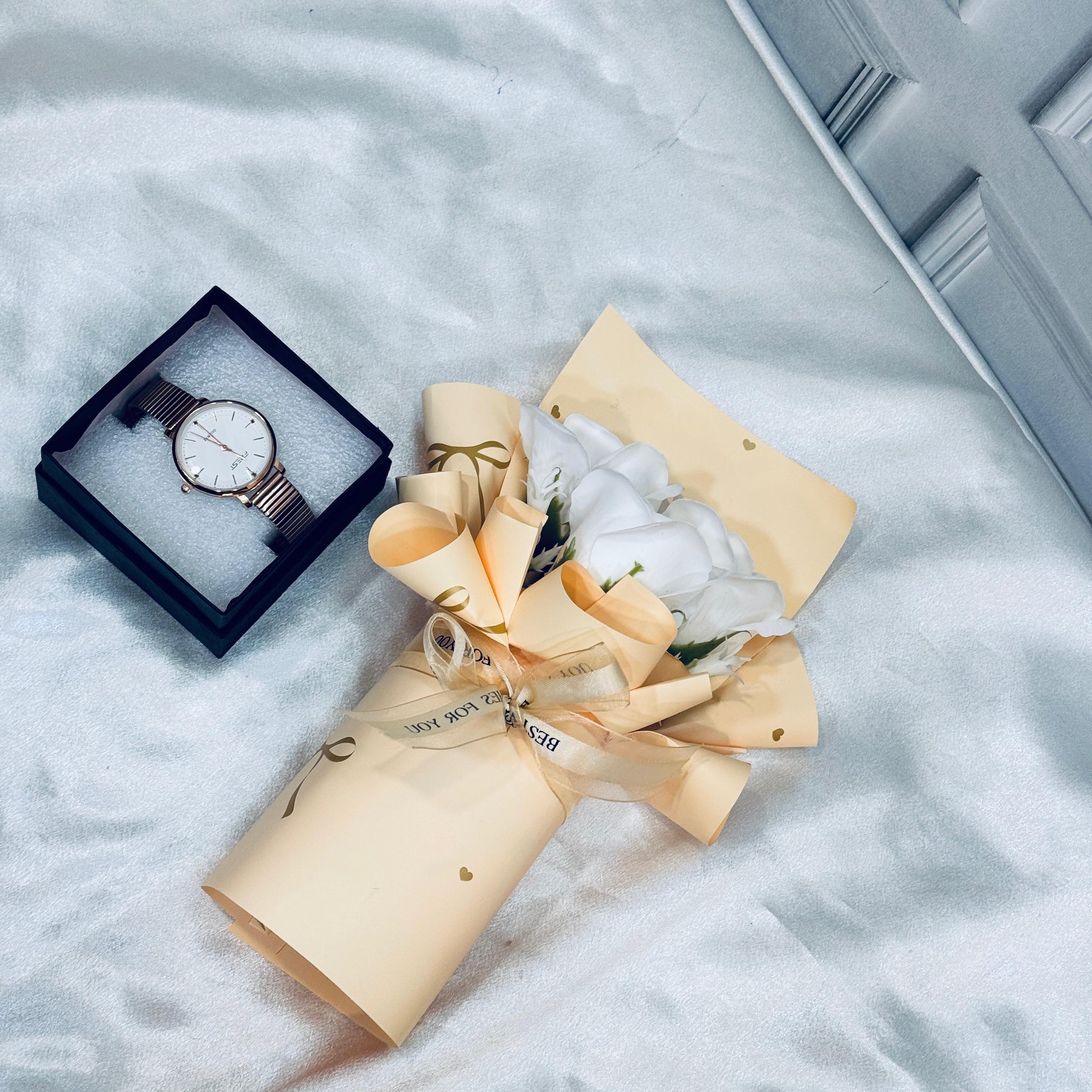 Women's luxury gift set with floral bouquet and elegant wristwatch